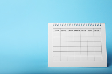 Photo of Blank paper calendar on light blue background, space for text. Planning concept