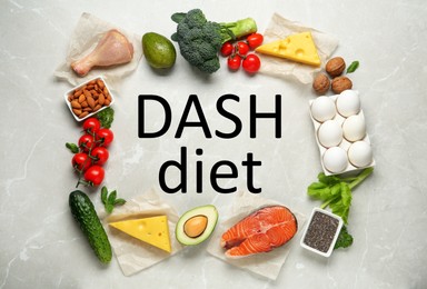 Dietary approaches to stop hypertension. Many different healthy food around words Dash diet on light marble table, flat lay