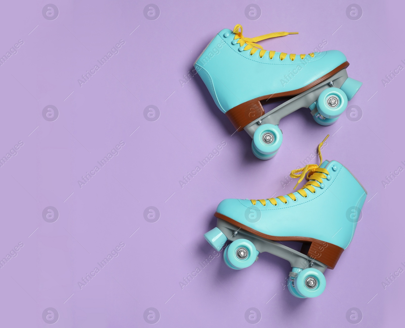 Photo of Pair of stylish quad roller skates on color background, top view with space for text