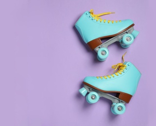 Pair of stylish quad roller skates on color background, top view with space for text