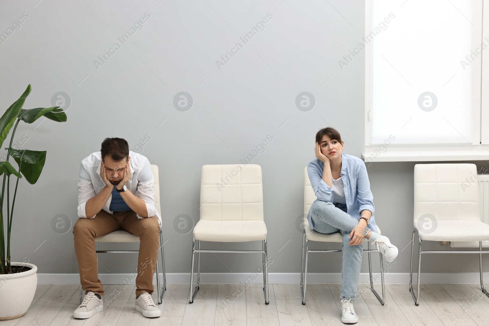 Photo of Man and woman waiting for appointment indoors