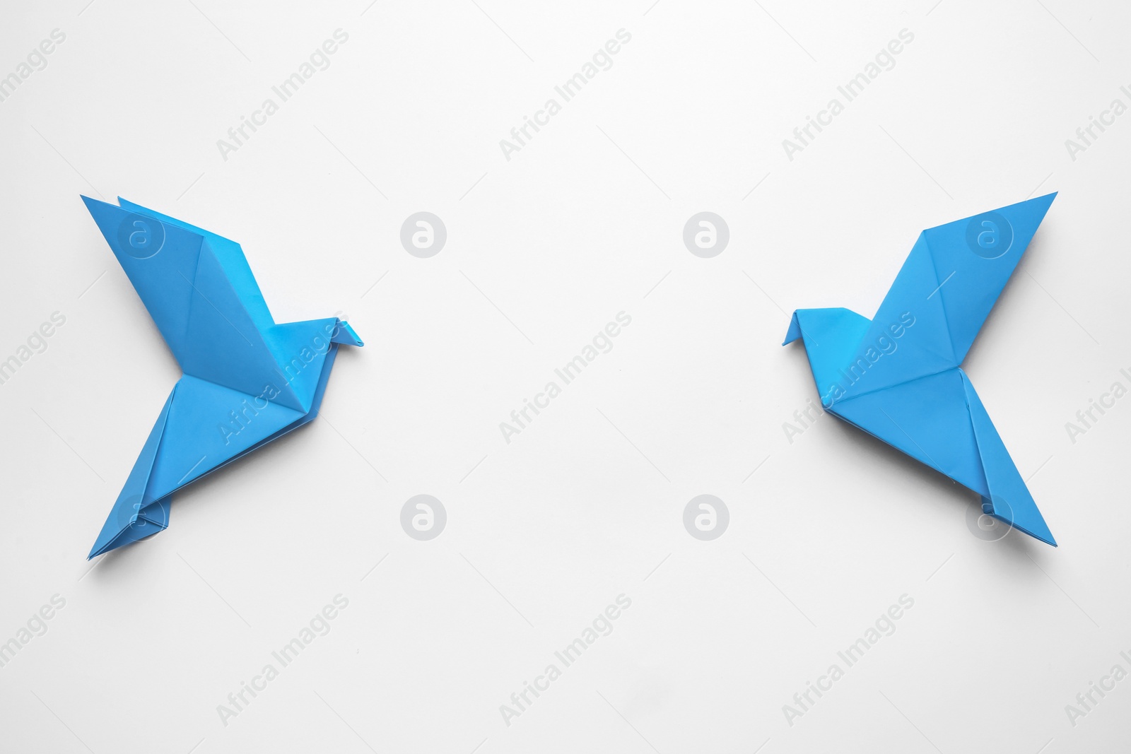 Photo of Beautiful blue origami birds on white background, flat lay. Space for text