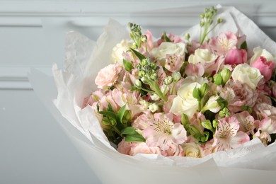 Photo of Beautiful bouquet of fresh flowers near grey wall, closeup