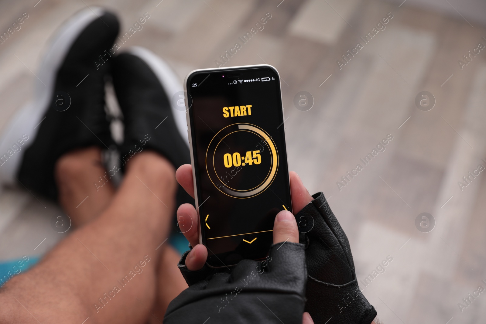 Photo of Man using fitness app on smartphone indoors, closeup