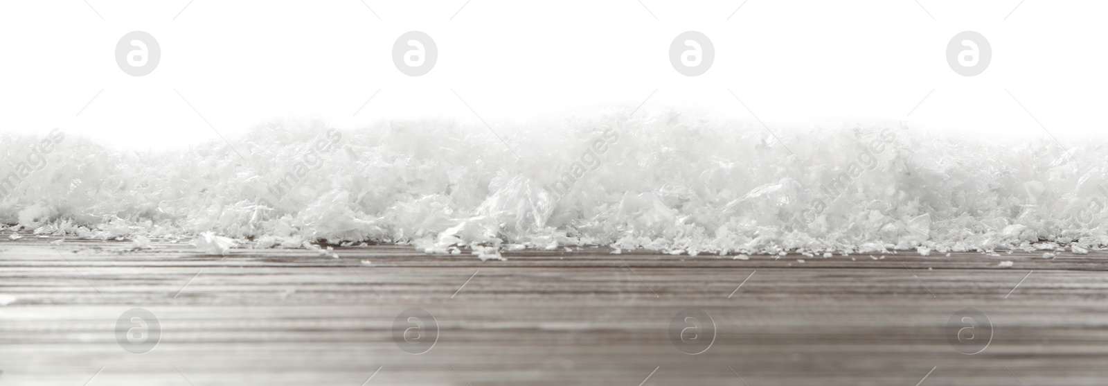 Photo of Snow on wooden surface against white background. Christmas season