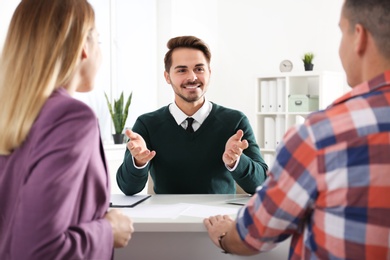 Real estate agent consulting young couple in office