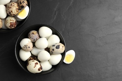 Photo of Unpeeled and peeled hard boiled quail eggs on black table, flat lay. Space for text