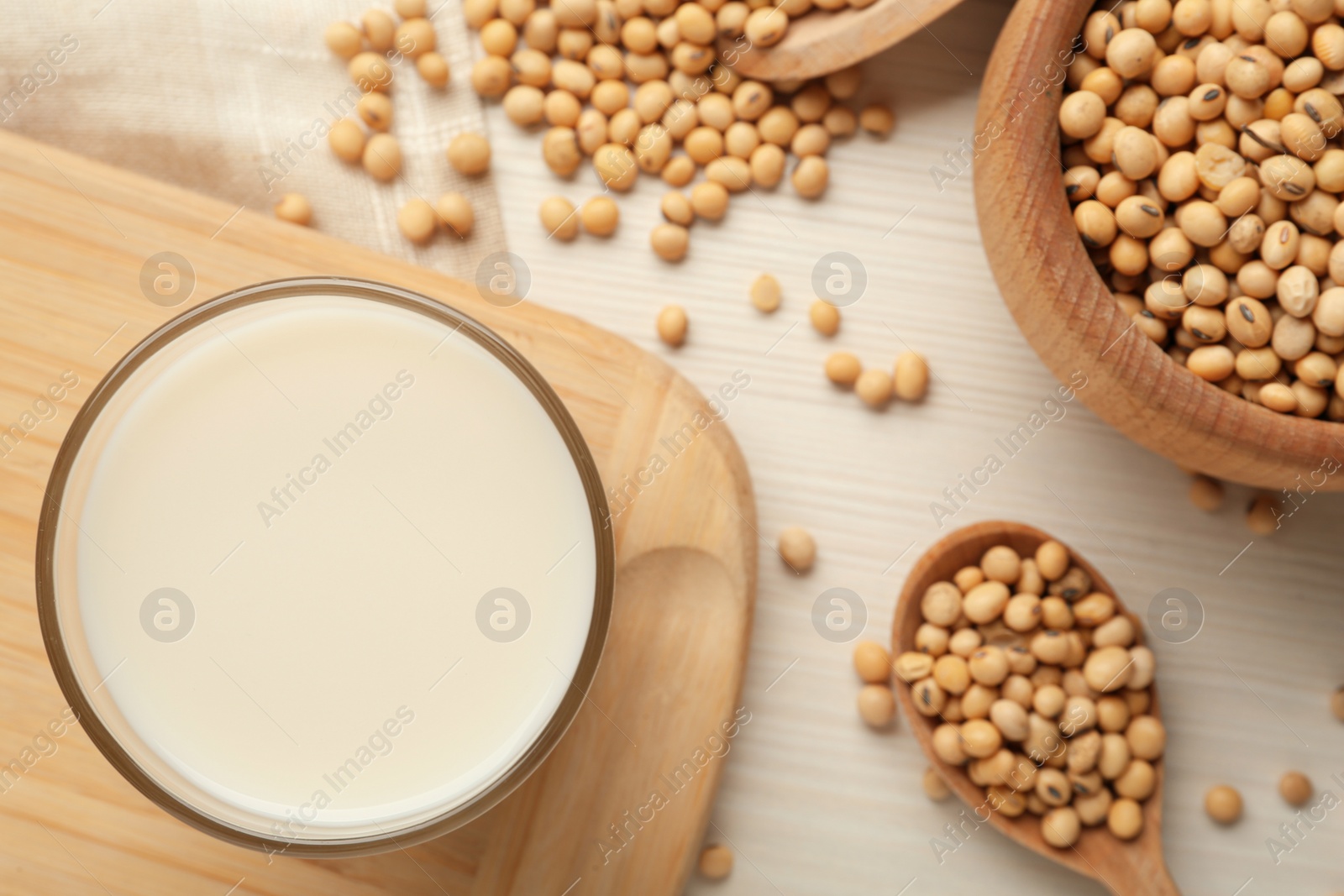 Photo of Fresh soy milk and beans on table, flat lay