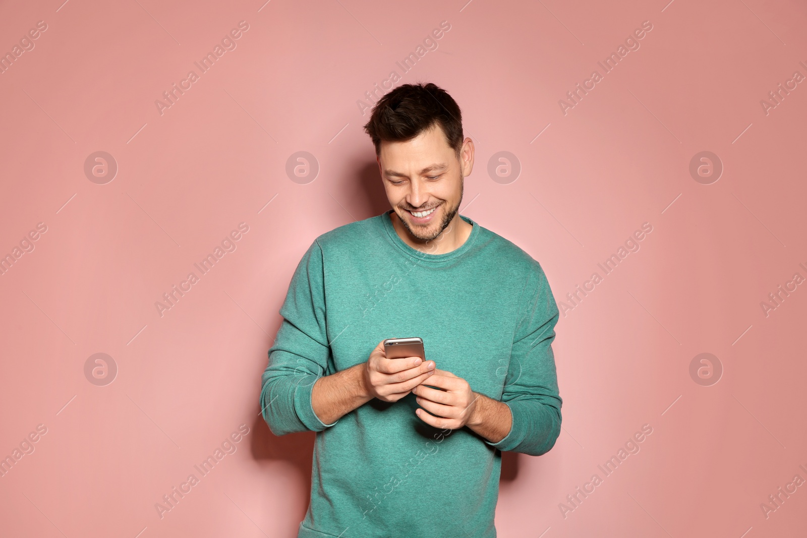 Photo of Handsome man with mobile phone on color background