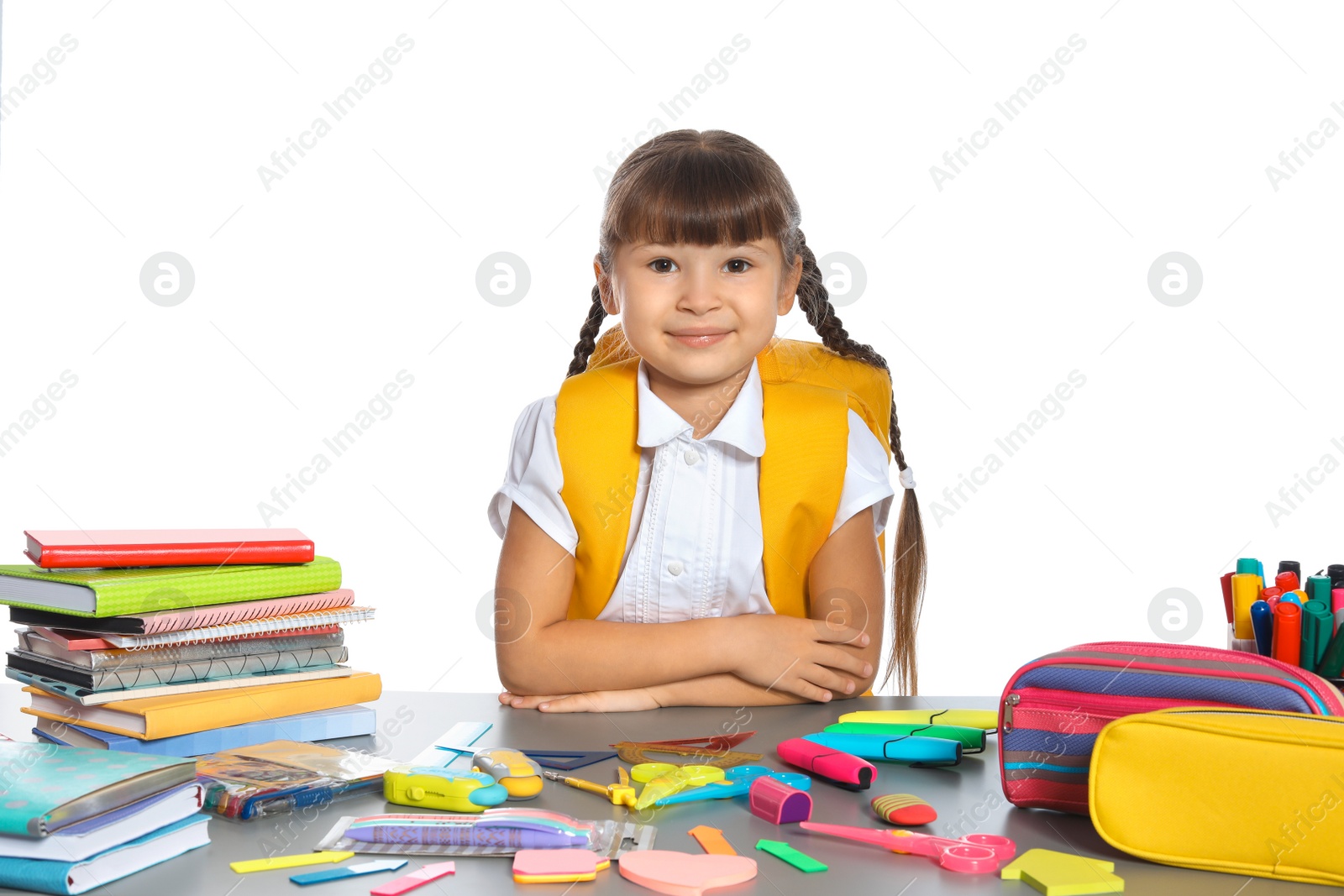 Photo of Schoolgirl at table with stationery against white background