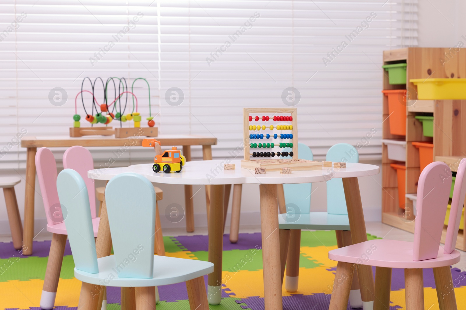 Photo of Stylish kindergarten interior with toys and modern furniture