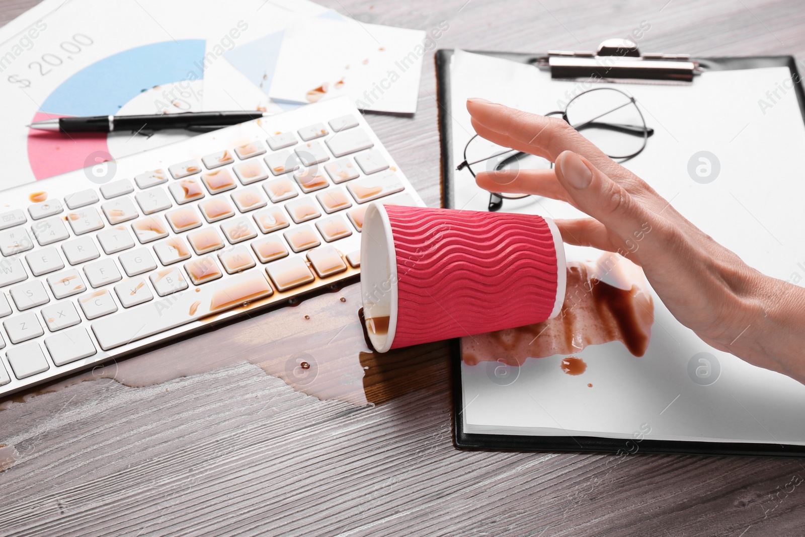 Photo of Woman with coffee spilled over her workplace, closeup