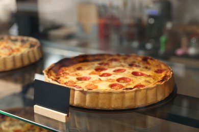 Delicious quiche with shrimps on counter in bakery shop, closeup. Space for text