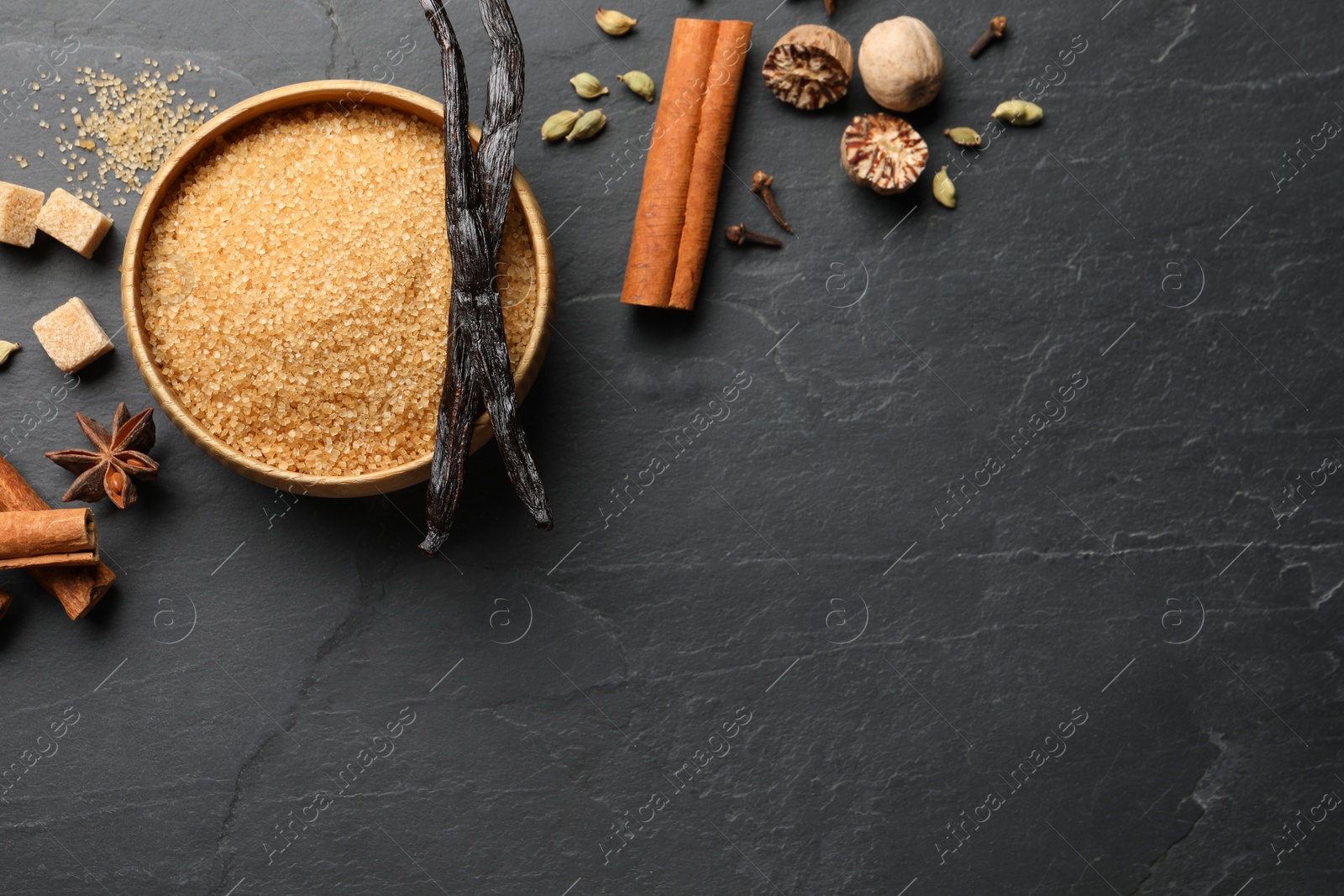 Photo of Different aromatic spices on dark textured table, flat lay. Space for text