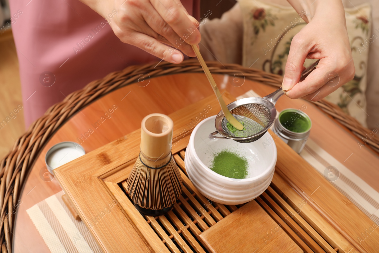 Photo of Master preparing matcha drink at wooden table, closeup. Tea ceremony