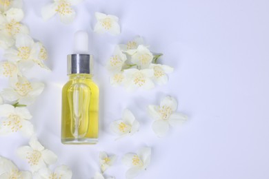 Photo of Essential oil in bottle and beautiful jasmine flowers on white background, flat lay. Space for text