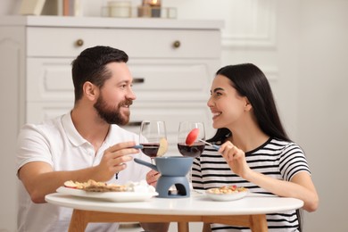 Affectionate couple enjoying fondue during romantic date at home