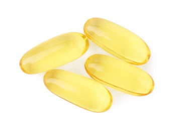 Photo of Many yellow vitamin capsules isolated on white, top view