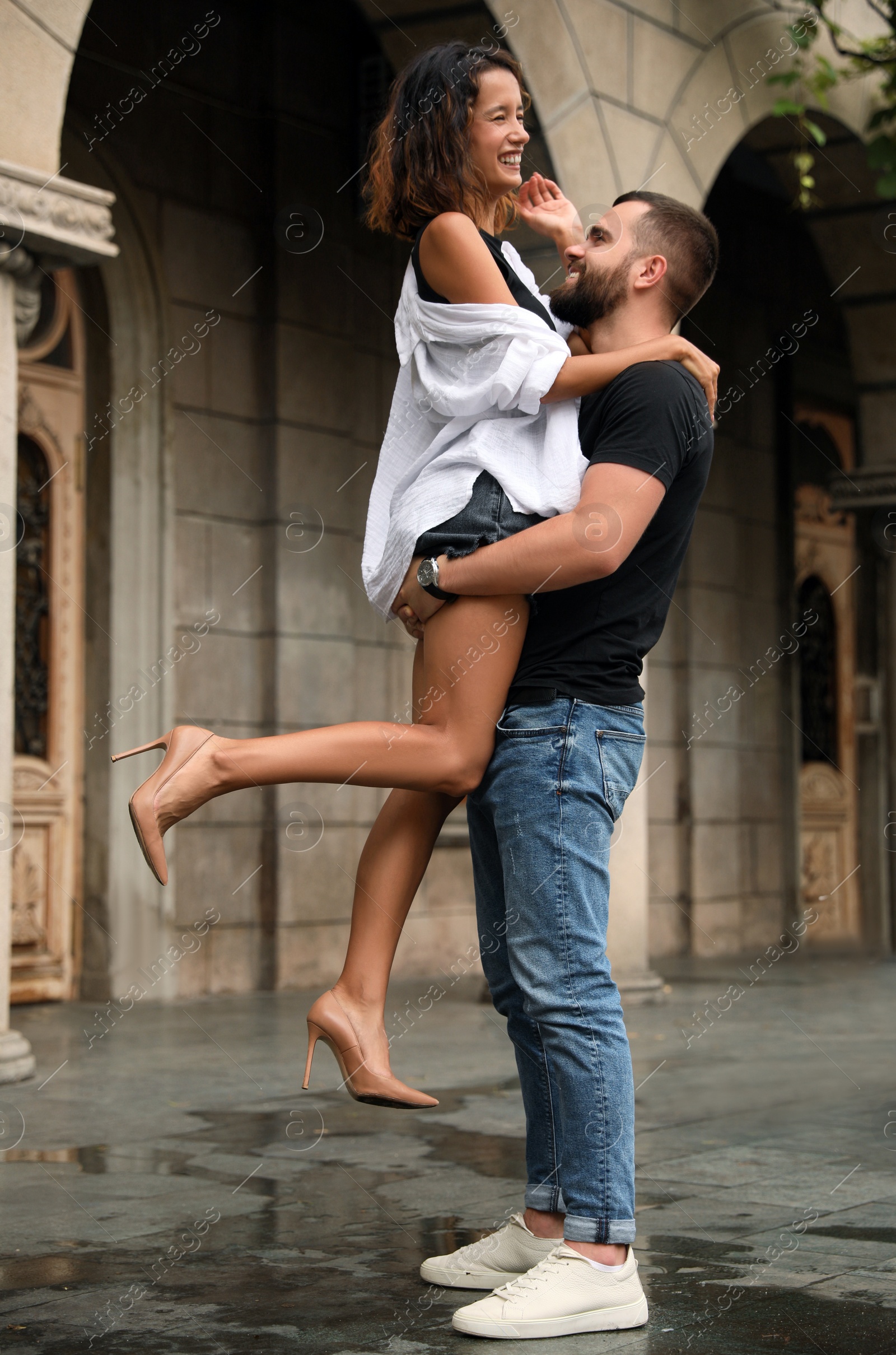 Photo of Young couple enjoying time together under rain on city street