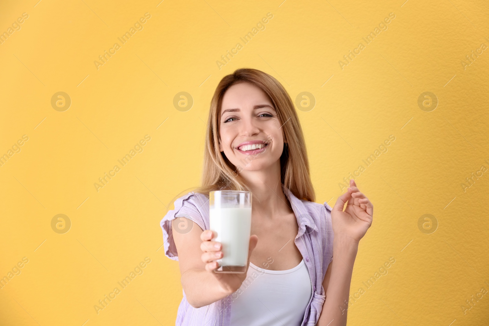 Photo of Beautiful young woman drinking milk on color background