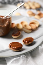 Photo of Delicious walnut shaped cookies with condensed milk on plate, closeup