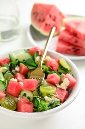 Photo of Delicious salad with watermelon served on white table, closeup