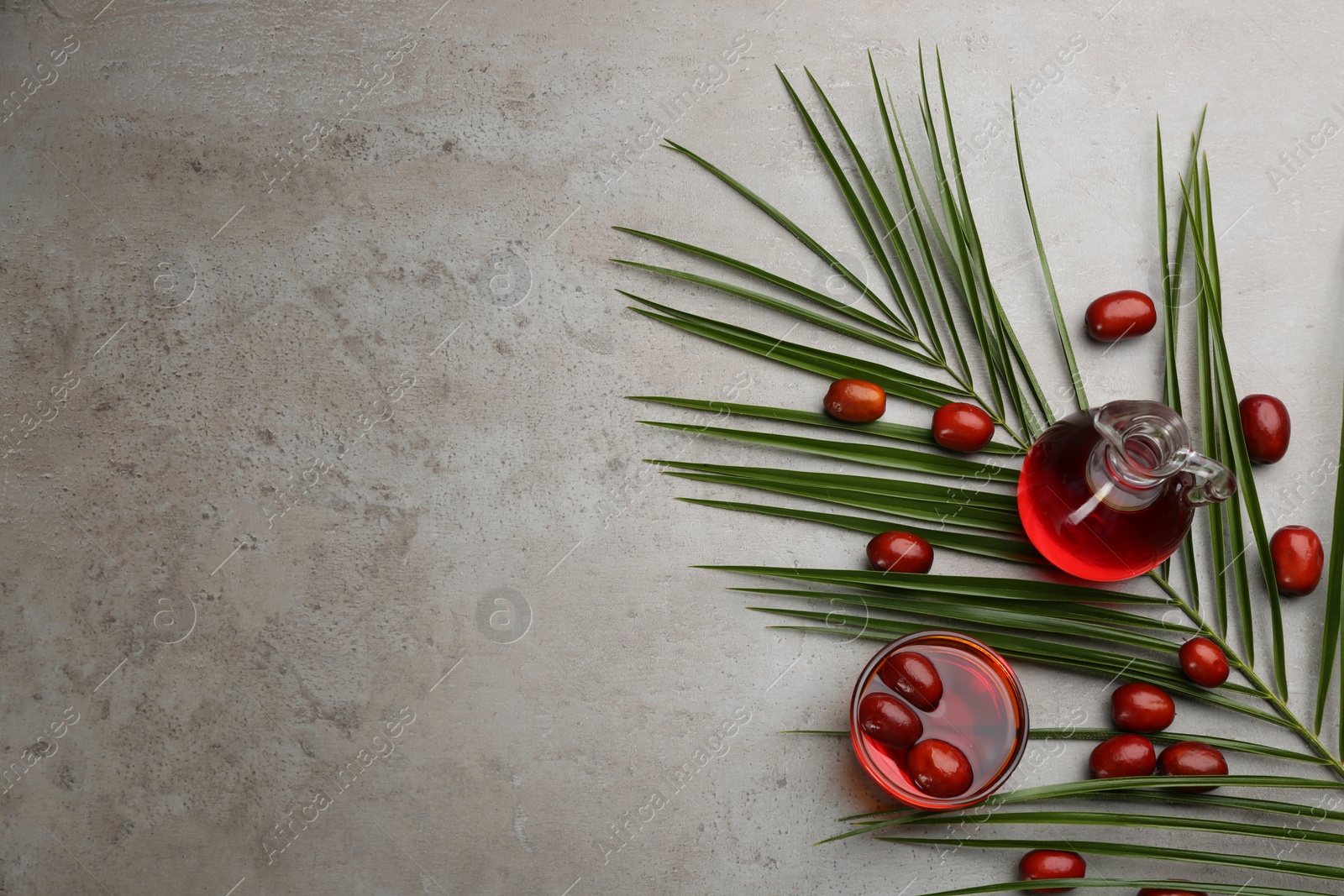 Photo of Flat lay composition with palm oil and fresh fruits on grey table. Space for text