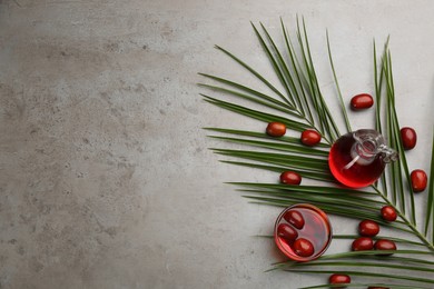 Flat lay composition with palm oil and fresh fruits on grey table. Space for text