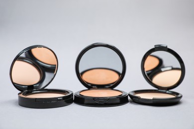 Photo of Open face powders with mirrors on light grey background