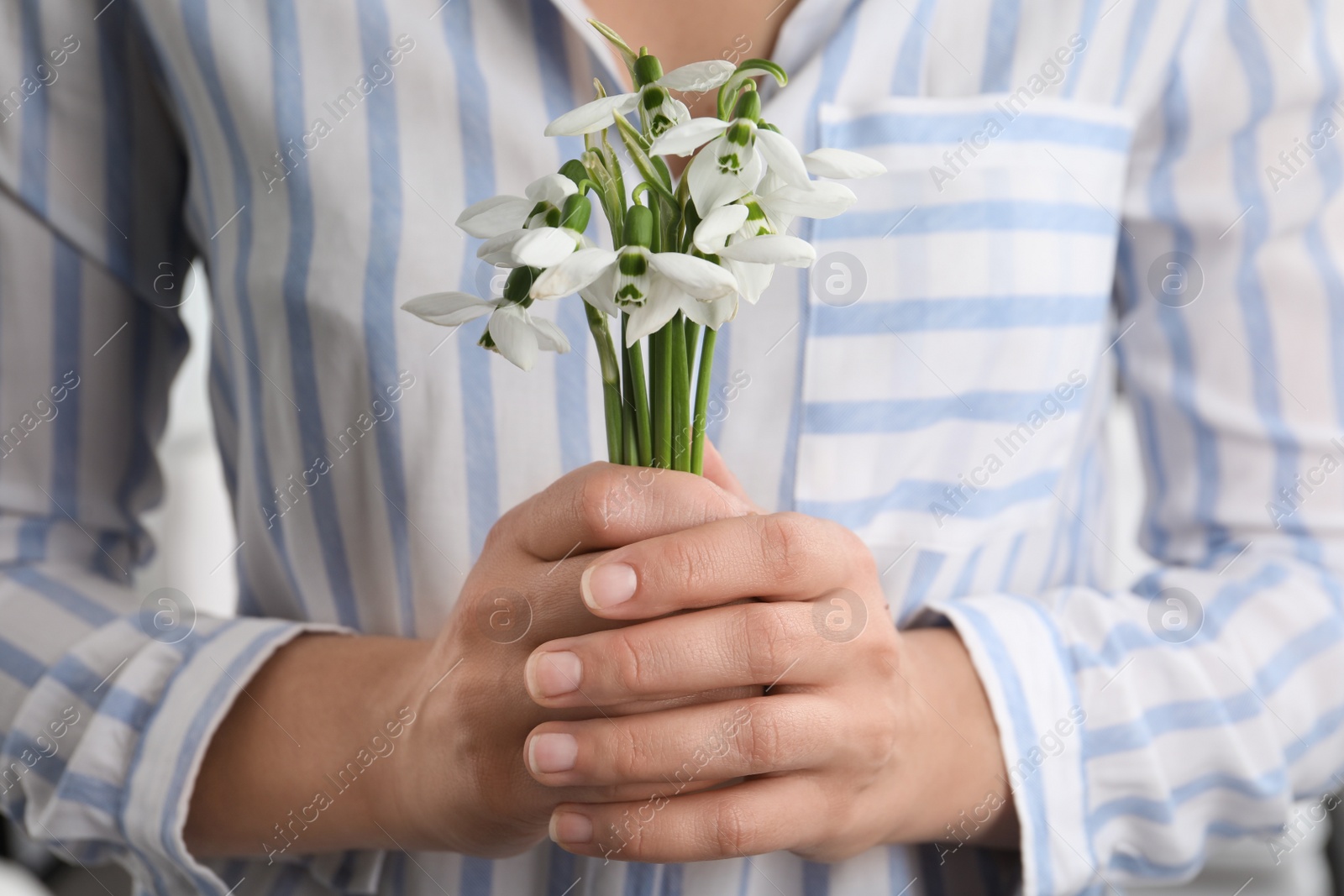 Photo of Woman holding beautiful bouquet of snowdrops, closeup