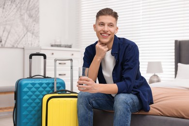 Photo of Smiling guest relaxing on bed in stylish hotel room