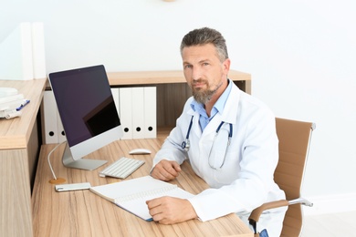 Photo of Male medical assistant at workplace in clinic. Health care service