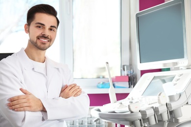 Sonographer near modern ultrasound machine in clinic, space for text