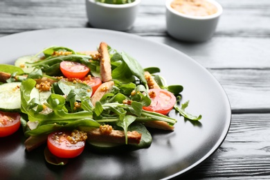 Photo of Delicious fresh chicken salad served on black wooden table, closeup