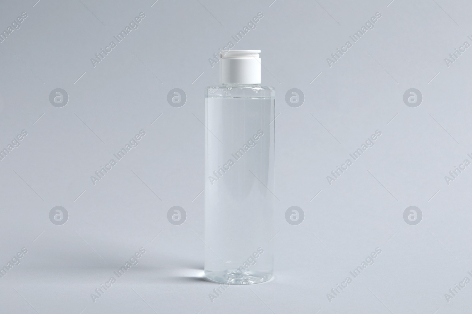 Photo of Bottle of cosmetic product on light grey background