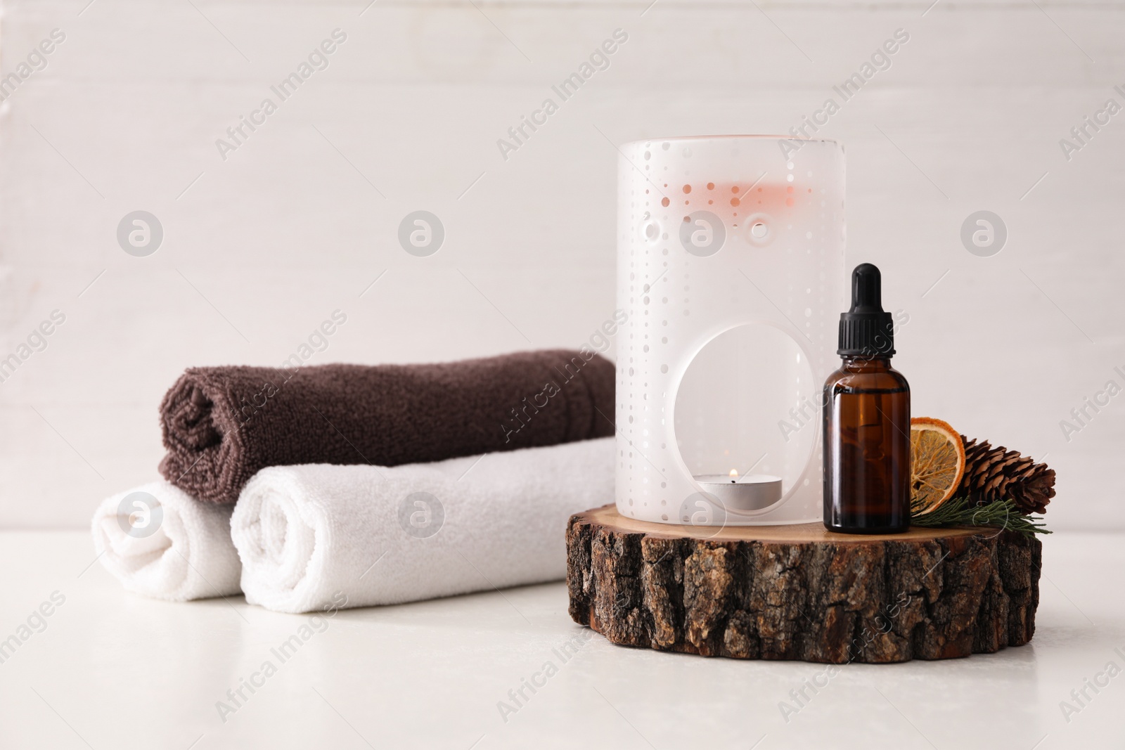 Photo of Composition with aroma lamp and coniferous essential oil on white table