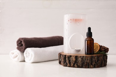 Photo of Composition with aroma lamp and coniferous essential oil on white table