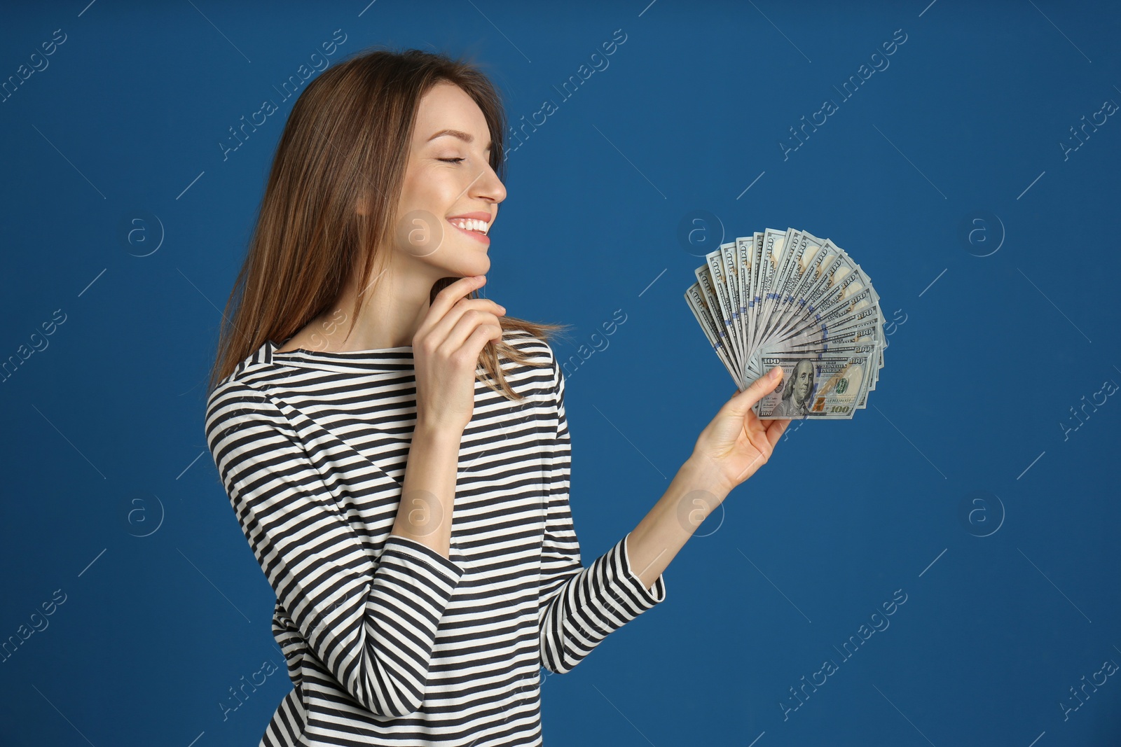 Photo of Happy young woman with cash money on blue background