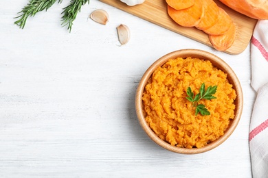 Flat lay composition with mashed sweet potatoes on wooden background, space for text