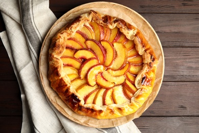 Photo of Delicious fresh peach pie on wooden table, top view