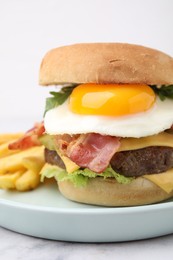 Photo of Delicious burger with fried egg and french fries served on white marble table, closeup