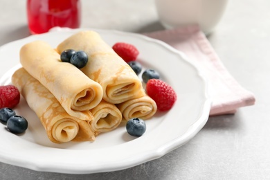 Thin pancakes with berries on plate