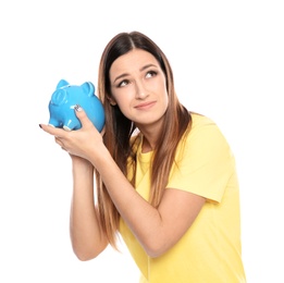 Young woman with piggy bank on white background