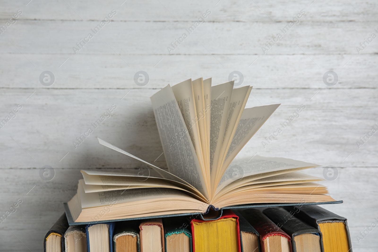 Photo of Stack of hardcover books on white wooden background