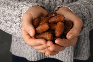 Woman holding handful of dried date fruits, closeup