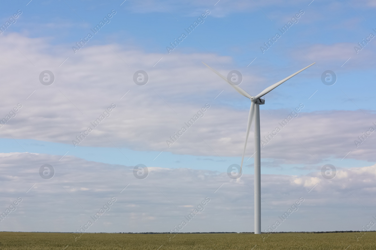 Photo of Beautiful view of field with wind turbine. Alternative energy source