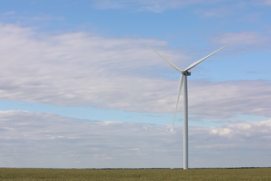 Beautiful view of field with wind turbine. Alternative energy source