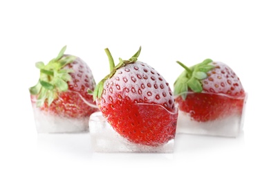 Photo of Fresh strawberries frozen in ice cubes on white background