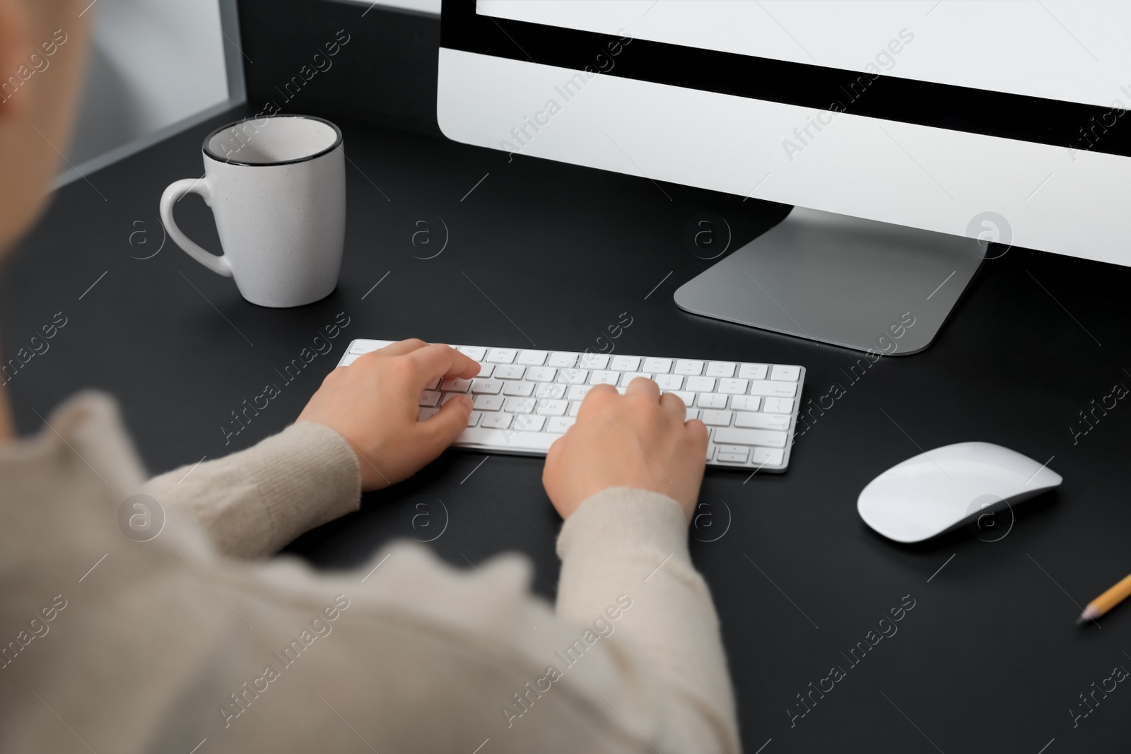 Photo of Woman working on modern computer at black table, closeup