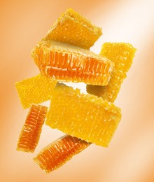 Image of Pieces of honeycomb falling on golden background